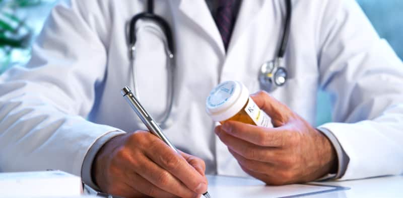 A doctor writing a prescription, emphasizing the importance of medical guidance and professional support in benzodiazepine detoxification