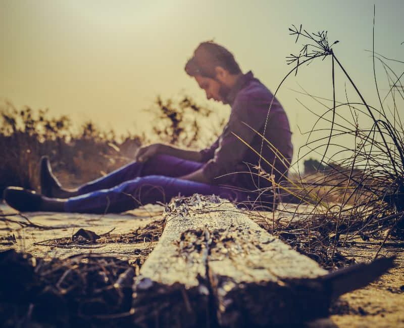 Despondent man on the beach, pondering the grip of the most addictive drugs on his life.