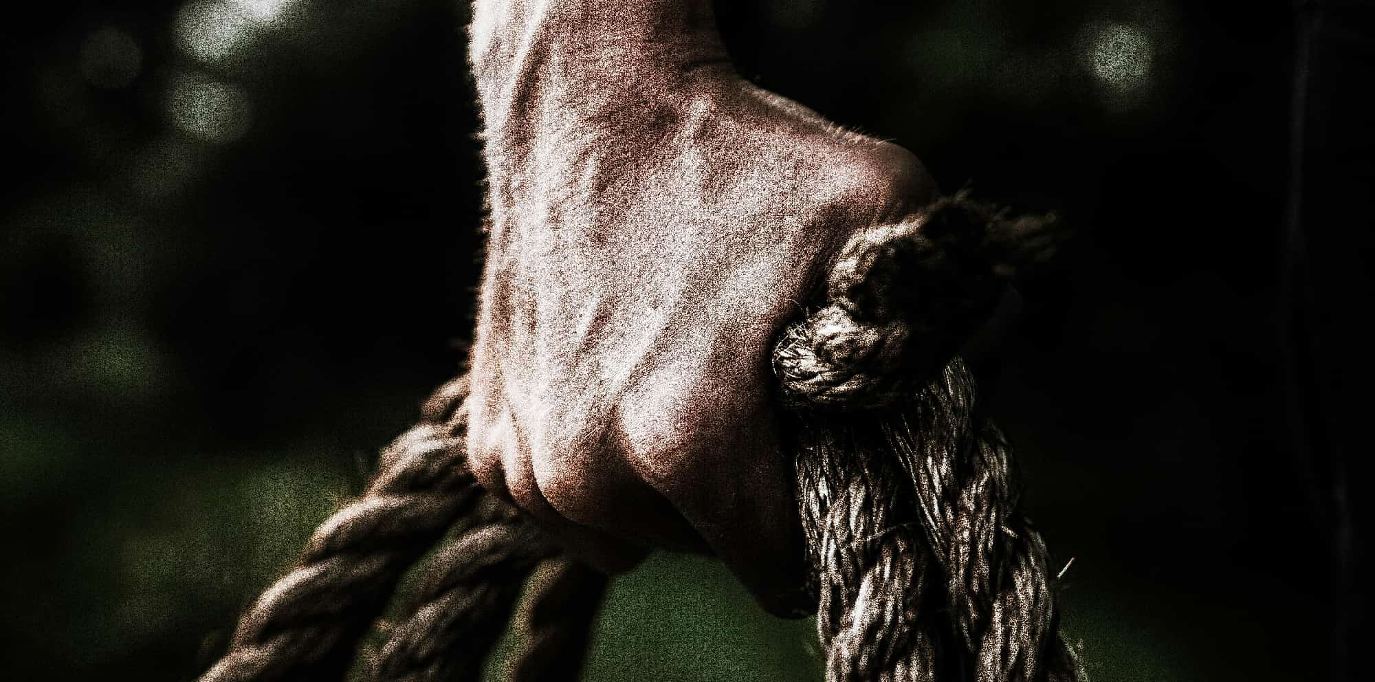 A close-up image showing a pair of white knuckles gripping a rope tightly, representing the struggle and determination involved in overcoming alcohol addiction.