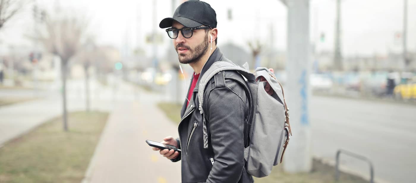 1. Man walking on a peaceful path through nature while listening to headphones, symbolizing the personal journey of overcoming alcohol addiction.