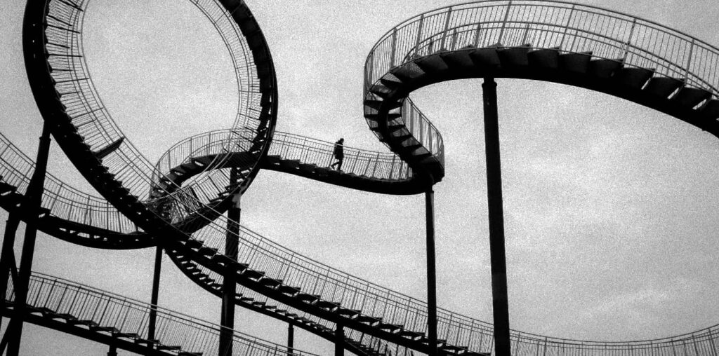 2. Close-up of a rollercoaster track with sharp twists and turns, symbolizing the emotional and situational ups and downs that are key reasons relapses happen in the journey of recovery.