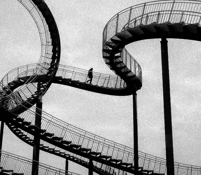 2. Close-up of a rollercoaster track with sharp twists and turns, symbolizing the emotional and situational ups and downs that are key reasons relapses happen in the journey of recovery.