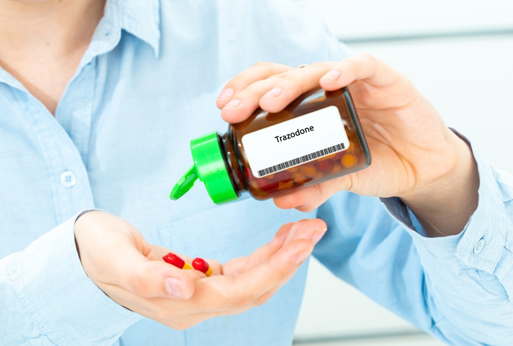 Closeup of hand with several trazodone pills 