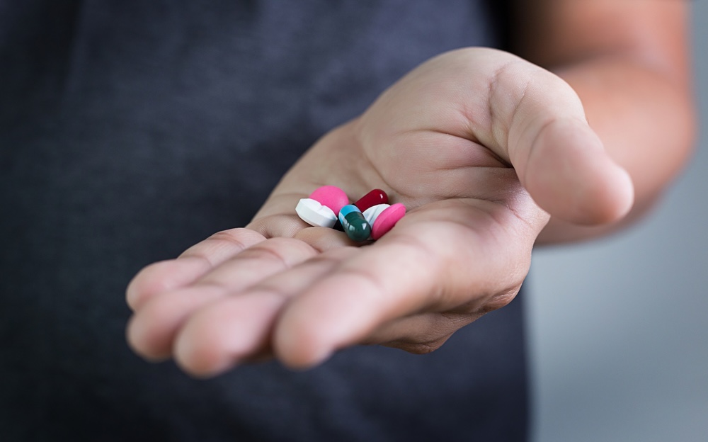 Man holding different benzos on the palm of his hand