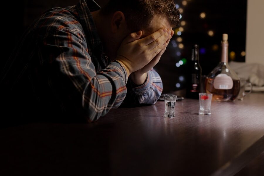 Man in a dimly lit bar dealing with alcohol addiction